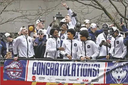  ?? JESSICA HILL/AP ?? UCONN PLAYERS RIDE ON A DOUBLE DECKER BUS during a parade to celebrate the team’s championsh­ip on Saturday in Hartford, Conn.