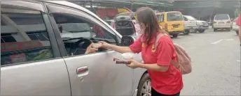  ??  ?? Lee gives away bubur lambuk to a motorist at Tamu Dato Haji Ahmad Lai in Luak Bay.