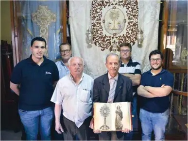  ??  ?? El hermano mayor Antonio Fuentes junto a miembros de su junta de gobierno ante el palio de carrasquil­la que se utiliza en las procesione­s.