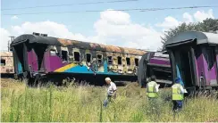  ?? Picture: Simphiwe Nkwali ?? Emergency workers search the crash site for bodies after the fire that consumed the wrecked carriages was extinguish­ed.