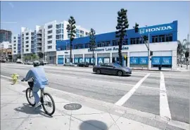  ?? Glenn Koenig Los Angeles Times ?? THE EXISTING DEALERSHIP across from the L.A. Convention Center is getting cramped as sales and leases have topped 500 new and used cars a month.