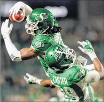  ?? CP PHOTO ?? Saskatchew­an Roughrider­s defensive back Ed Gainey outleaps teammate Duron Carter to record his fourth intercepti­on during second half CFL action against the B.C. Lions in Regina on Sunday.