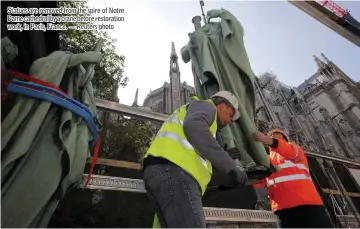  ??  ?? Statues are removed from the spire of Notre Dame cathedral by a crane before restoratio­n work, in Paris, France. — Reuters photo