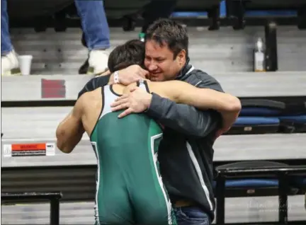  ?? SHARON HOLY — FOR THE NEWS-HERALD ?? Lake Catholic senior Dakota Ryan hugs his father Darren matside after winning his consolatio­n semifinal at the Alliance District wrestling tournament on March 2, clinching a berth in the state tournament next weekend.