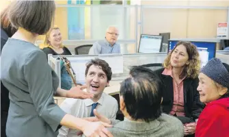  ??  ?? Prime Minister Justin Trudeau talks to clients and staff during a visit to the Employment Services Centre of WoodGreen Community Services in Toronto on Wednesday.