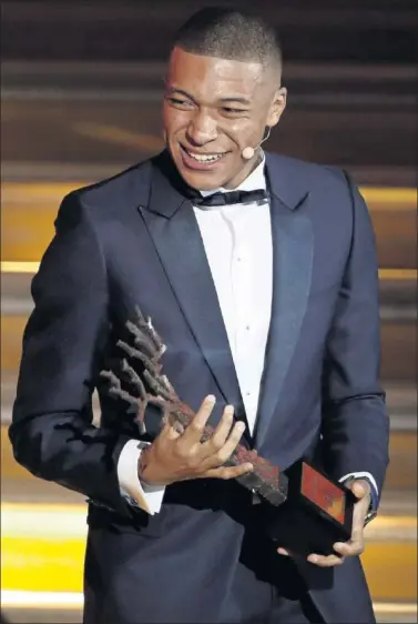  ??  ?? CON SU TROFEO. Mbappé sonríe al recoger el premio Kopa al mejor jugador Sub-21.