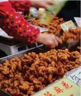  ??  ?? Fried twisted dough is sold in Ciqikou.