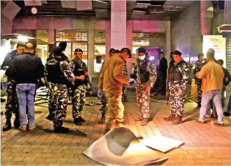  ?? AFP ?? Lebanese security forces inspect the area near the Fransabank branch in Sidon after assailants targeted the bank’s entrance with an explosive device.