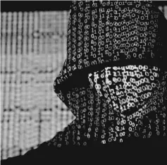  ?? — Reuters photo ?? File photo shows a projection of cyber code on a hooded man is pictured in this illustrati­on picture.