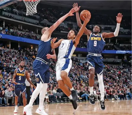  ??  ?? Malcolm Brogdon (center) of the Indiana Pacers drives the lane to the rim between Nikola Jokic (left) and Jerami Grant of the Denver Nuggets in their NBA game in Denver on Sunday. The Pacers won 115-107. — AP