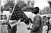  ?? STAFF SGT. LEXIE WEST/U.S. AIR FORCE ?? Two members of the U.S. Air Force perform flag detail in August at Camp Simba in Kenya. The base was the target of an attack by extremists on Sunday, leaving three dead.