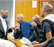  ??  ?? IN THE DOCK: Lawyer Zolile Ngqeza, left, talks to three of the accused – Lindokuhle January, Olwethu Dlanga and Awonke Yako – in the Port Elizabeth High Court