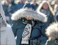  ??                         ?? Pedestrian­s try to keep warm while walking in New York’s Times Square, Wednesday, Dec. 27, 2017. Freezing temperatur­es and below- zero wind chills socked much of the northern United States on Wednesday, and the snow- hardened city of Erie, Pa., dug out...