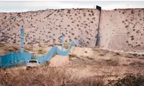  ?? RUSSELL CONTRERAS/ASSOCIATED PRESS ?? A U.S. Border Patrol agent drives near the U.S.-Mexico border fence. A new border poll released last week says a majority of residents on both sides of the border are against a wall.