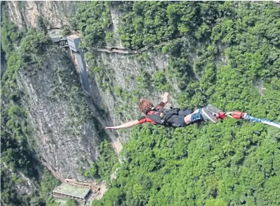  ?? Pictures: SWNS. ?? Callum Lewis, 25, got the once in a lifetime opportunit­y to bungee jump off the 260 metre-high Zhangiajie Grand Canyon Glass Bridge in China after helping set it up.