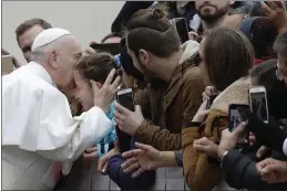  ?? PHOTOS BY ALESSANDRA TARANTINO — THE ASSOCIATED PRESS ?? Pope Francis kisses a child in St. Peter’s Square at the Vatican before leaving after his weekly general audience, Wednesday.