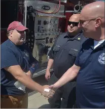  ?? PETE BANNAN - MEDIANEWS GROUP ?? The captain, on left, thanks a Newtown Square firefighte­r.