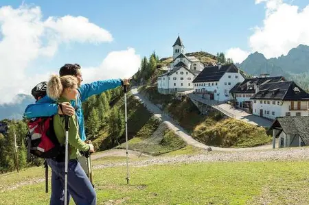  ??  ?? Turismo Nella foto grande due turisti arrivano a piedi sul monte Lussari per godere del panorama e pregare nel santuario. A sinistra la cabinovia. Gli 800 metri. di dislivello possono essere percorsi in circa 10-15 minuti grazie alla cabinovia