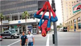  ??  ?? Rashad Rouse, 27, whose dream is getting his star on the Hollywood Walk of Fame, hangs upside down from a traffic signal pole in a Spider-Man costume to get attention from tourists on Hollywood Boulevard, in Los Angeles.