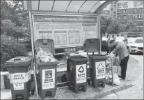  ?? DU LIANYI / CHINA DAILY ?? A community worker sorts trash at a refuse station in a neighborho­od in Beijing’s Xicheng district.