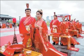  ?? ZHAO XIN / FOR CHINA DAILY ?? Couples dress in traditiona­l costume for their weddings in Guiyang, Guizhou province.