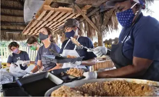  ?? CARL JUSTE cjuste@miamiheral­d.com ?? Food Rescue U.S. volunteers, left to right, Danayse Elias, Nicky Minski and Jodi Bondy help restaurant employees prepare meals to be donated.