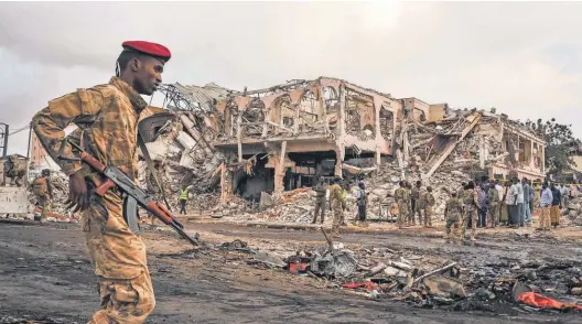  ?? MOHAMED ABDIWAHAB, AFP/ GETTY IMAGES ?? Somali soldiers stand guard after an explosion rocked Mogadishu.