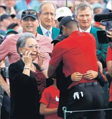  ?? REUTERS ?? Tiger Woods embraces his daughter Sam Alexis as son Charlie Axel (partly hidden) and mother Kultida (left) look on.