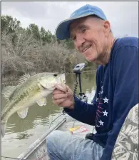  ?? (Arkansas Democrat-Gazette/Bryan Hendricks) ?? Jim Bell of Little Rock admires one of the bass he caught recently while fishing with Bob Snider and the author in Monroe County.