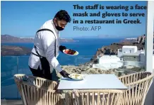  ??  ?? The staff is wearing a face mask and gloves to serve in a restaurant in Greek.