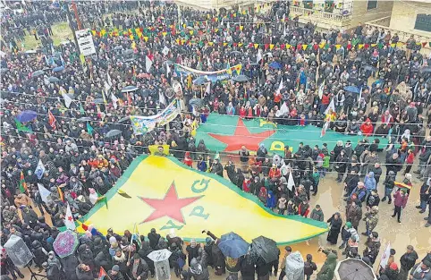  ?? AP ?? Protesters wave giant flags of the Kurdish militia, People’s Protection Units or YPG, during a demonstrat­ion against Turkish threats in Afrin, north Syria, on Thursday.