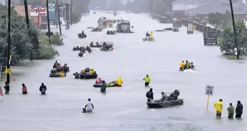  ?? DAVID J. PHILLIP/THE ASSOCIATED PRESS ?? Rescue boats fill a flooded street to help evacuate victims as waters from Tropical Storm Harvey continued to rise Monday. Local officials reported 10 deaths possibly related to the storm.