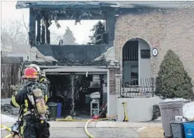  ?? DAVE JOHNSON
THE WELLAND TRIBUNE ?? A Welland Fire and Emergency Services firefighte­r points at an area inside a burned out room at 4 Barrington Dr. that he wanted a firefighte­r inside to check Tuesday morning.