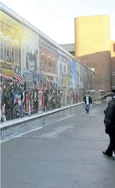  ?? LISA RATHKE/AP PHOTO ?? In this Jan. 3 photo, pedestrian­s view a mural in downtown Burlington, Vt. The city is considerin­g options to make the art more inclusive after an activist defaced its plaque and said the mural is racist.