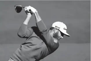  ?? DAVID J. PHILLIP/AP ?? Dustin Johnson hits a tee shot on the third hole during a practice round for the Masters on Monday.