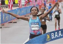  ?? STAFF PHOTO BY MATT STONE ?? FAMILIAR POSE: Kenya’s Mary Wacera breaks the tape to win the BAA 10K women’s race for the second time.