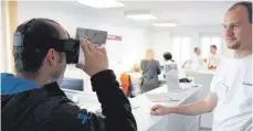  ??  ?? Digital-Redakteur Michael Kroha (rechts) erklärt einem Besucher, was die VR-Brille alles kann: Videos in 360 Grad hautnah erleben.