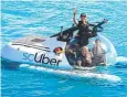  ??  ?? DIFFERENT: Tourism Minister Kate Jones launches "scUber" with chief pilot Erika Bergman and Uber regional general manager Susan Anderson.
