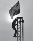  ?? RAVI CHOUDHARY/HT ?? A worker puts up the Tricolour in New Delhi, August 9