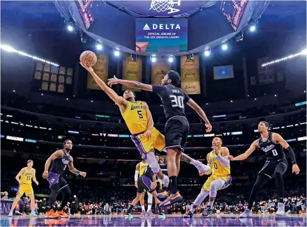  ?? —
AFP ?? Talen Horton-Tucker (No.5) of the Los Angeles Lakers scores as he is fouled by Damian Jones (No.30) of the Sacramento Kings during their NBA basketball game at Staples Center in Los Angeles, California (USA) on Tuesday. The Lakers won 122-114.