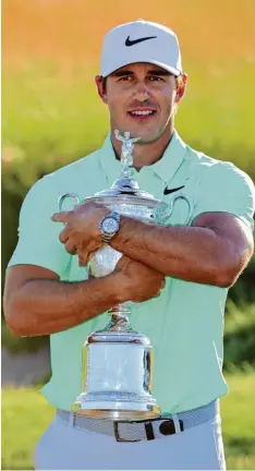  ?? Foto: Streeter Lecka , afp ?? Den gebe ich nicht mehr her: Brooks Koepka umarmt nach seinem Sieg in Erin Hills den Pokal für den US Open Gewinner. Stephan Jäger nach dem schwachen Finale.