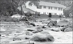  ?? AP/Santa Barbara County Fire Department/MIKE ELIASON ?? Rocks, mud and debris cover a street in Montecito, Calif., on Tuesday. Marks on the house in the background show how high the mud rose as it swept through the neighborho­od.