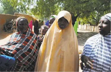  ?? Jossy Ola / Associated Press ?? Falmata Abubakar (center) is one of the girls who were returned to their families in Dapchi, Nigeria.