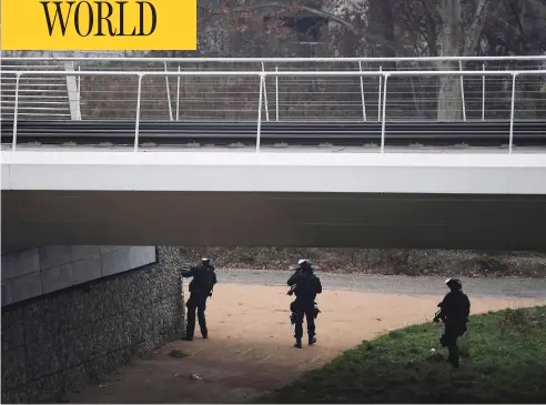 ?? FREDERICK FLORIN / AFP / GETTY IMAGES ?? Members of the French police special forces RAID conduct searches on a bank of the river Rhine in Strasbourg on Wednesday in their hunt for the gunman who opened fire near a Christmas market Tuesday night in Strasbourg, France. Two have died and 13 are injured.