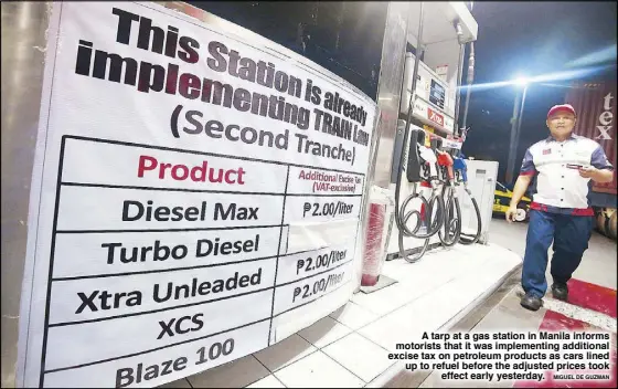  ?? MIGUEL DE GUZMAN ?? A tarp at a gas station in Manila informs motorists that it was implementi­ng additional excise tax on petroleum products as cars lined up to refuel before the adjusted prices took effect early yesterday.