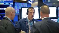  ?? Nicole Pereira/NYSE via AP ?? Trader Gregory Rowe, center, works Friday on the New York Stock Exchange trading floor. Stocks fell again Friday, ending their worst week since the financial crisis of 2008.