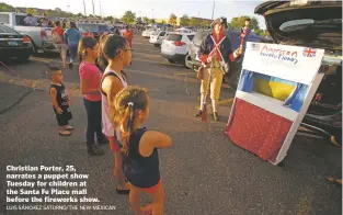  ?? LUIS SÁNCHEZ SATURNO/THE NEW MEXICAN ?? Christian Porter, 25, narrates a puppet show Tuesday for children at the Santa Fe Place mall before the fireworks show.