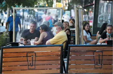  ?? KATHY WILLENS — THE ASSOCIATED PRESS ?? Plastic partitions separate patrons at Jake’s Dilemma the first day of the phase two reopening of the city during the current coronaviru­s outbreak June 22, in New York.