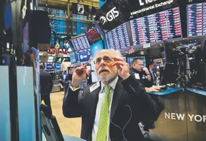  ?? Spencer Platt, Getty Images ?? Traders work on the floor of the New York Stock Exchange on Tuesday in New York. The Dow Jones industrial average fell nearly 800 points as investors’ fears increased over a potential trade war between the U.S. and China.