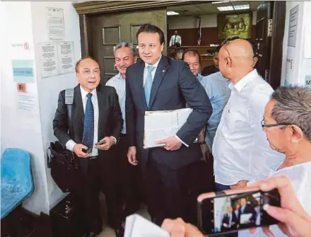  ?? PIC BY KHAIRULL AZRY BIDIN ?? Lawyers Datuk Douglas Lind (left) and Tengku Fuad Tengku Ahmad (second from left) leaving the court’s chambers at the Kota Kinabalu High Court yesterday.